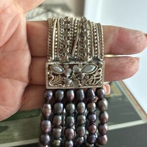 Iridescent pearls and crystals very beautiful. Too big for my tiny wrist.